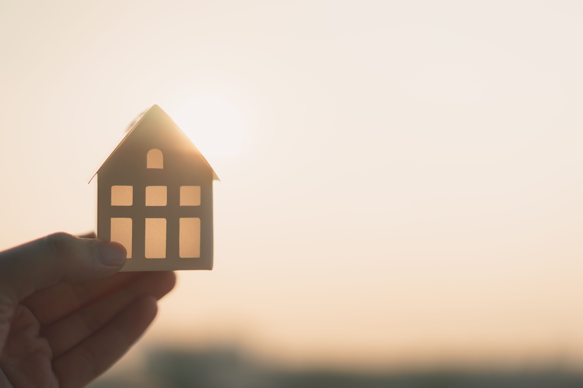 Modello di casa nella mano dell'agente di intermediazione assicurativa domestica o nel venditore. Agente immobiliare offre casa, assicurazione immobiliare e sicurezza, concetti abitativi a prezzi accessibili
